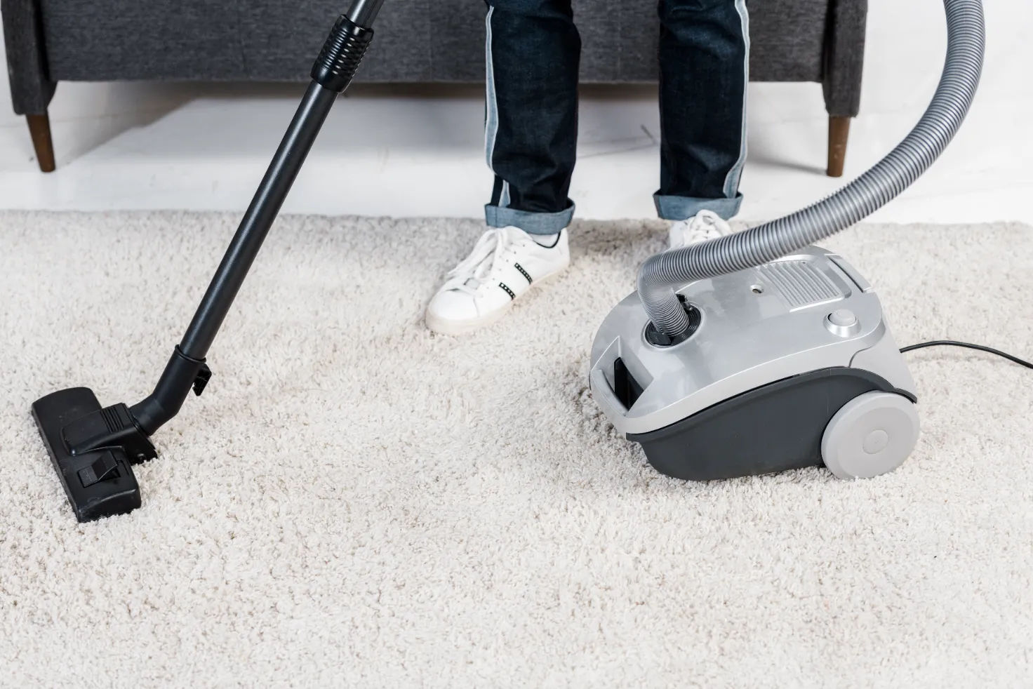 A worker ready to clean the dirty carpet with some vacuum cleaner.